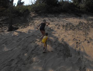 Deb & Kyle race up the small dune at Sandhill Park
